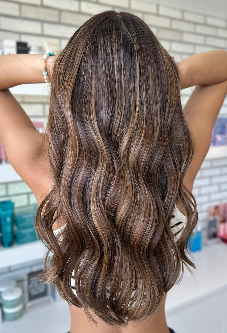 Asian custom blonding A photo of the back of a long haired client with a dimensional dark blonde color.